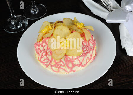 Multi-Schicht-Salat mit Mayonnaise mit den Blumen von chips Stockfoto