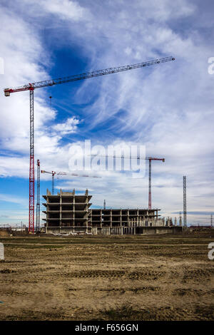 Baustelle in der Entwicklung, mit Kranen im Hintergrund, ein bewölkter Himmel Stockfoto