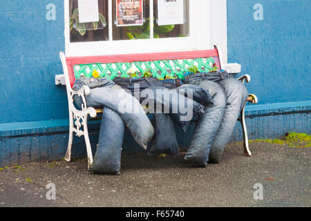 Upcycling - alte Jeans auf der Bank sitzend, pflegte Blumen in llandovery, Carmarthenshire, Mid Wales UK im November zu wachsen Stockfoto