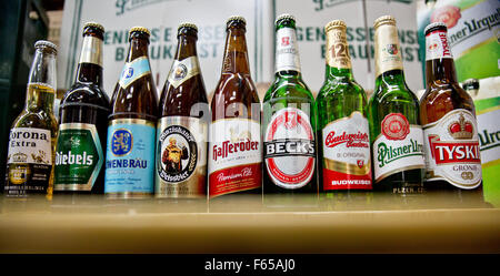 Datei - Datei Bild datiert 13. Oktober 2015 zeigt Bierflaschen aus dem Unternehmen Anheuser-Busch InBev, einschließlich Marken Corona (L-R), Diebels, Loewenbraeu, Franziskaner, Hasseroeder, Becks und Budweiser neben Flaschen der Marken Pilsner Urquell und Tyskie von der Firma SABMiller in Nürnberg. Foto: Daniel Karmann/dpa Stockfoto