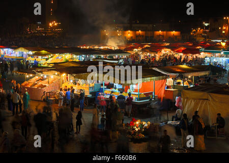 Die typische Atmosphäre der berühmten Marrakesch Platz mit viel Essen, traditioneller Musik, Aromen von Gewürzen und traditionellen cra Stockfoto