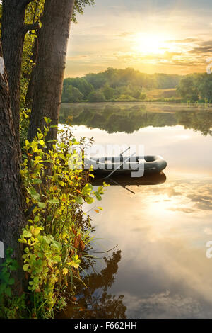 Schlauchboot auf Fluß an den Sonnenaufgang Stockfoto