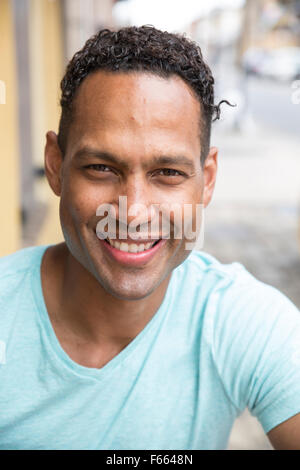 Kopfschuss von jeder ethnischen Mann lächelnd, mit einem leichten blau grün T-shirt. Stockfoto