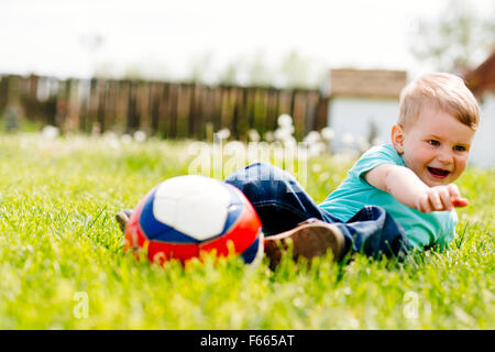 Entzückende kleine Jungen spielen mit einem Fußball im freien Stockfoto