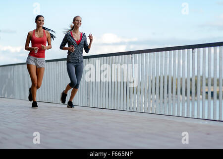 Zwei sportliche Frauen Joggen in der Stadt beim Musikhören Stockfoto