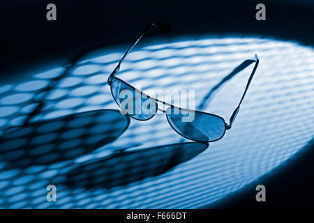 Blau getönten Foto von Sonnenbrillen in punktierten Licht. Stockfoto