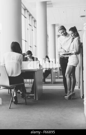 Junge Studenten zusammen in einer Bibliothek Stockfoto