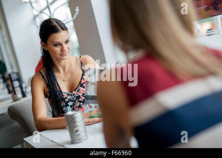 Hübsche Frauen Menü im Restaurant betrachten und entscheiden, was zu bestellen Stockfoto