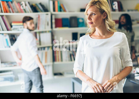 Porträt einer schönen Frau im Büro mit Kollegen im Hintergrund Stockfoto