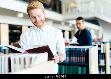 Gut aussehend Student liest ein Buch eine wunderschöne Bibliothek Stockfoto