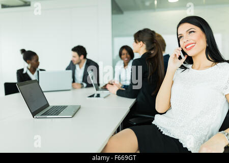 Schöne junge Geschäftsfrau lächelnd und glücklich während Geschäftstreffen reden