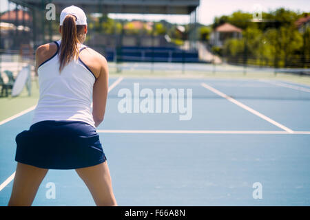 Tennisspielerin in einer empfangenden Service-Haltung Stockfoto