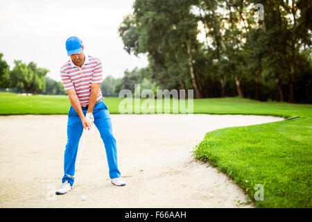 Golfer, die unter einem Bunker geschossen mit dem Ball im sand Stockfoto