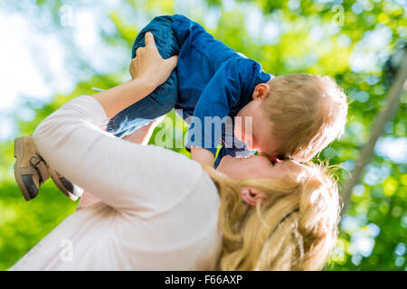 Schöne junge Mutter spielen und lächelnd mit ihrem hübschen kleinen Sohn Stockfoto
