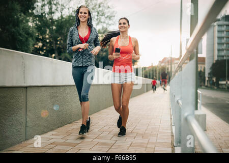 Schöne Landschaft von zwei weiblichen Jogger verfolgt ihre Aktivitäten im Freien in der Stadt in der Dämmerung Stockfoto