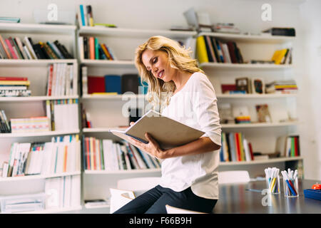 Atemberaubende blonde Frau lesen Stockfoto