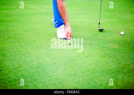 Golfspieler, die Reparatur Divot auf einer grünen Rasenfläche Stockfoto