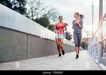 Schöne Landschaft von zwei weiblichen Jogger verfolgt ihre Aktivitäten im Freien in der Stadt in der Dämmerung Stockfoto