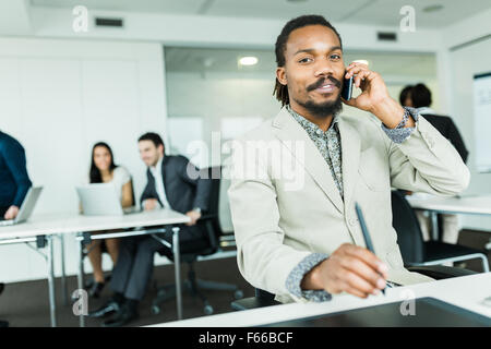 Schwarze schöne Grafik-Designer mit Dreadlocks mit Digitizer in einer gut beleuchteten, ordentlich Büroumgebung und sprechen Stockfoto