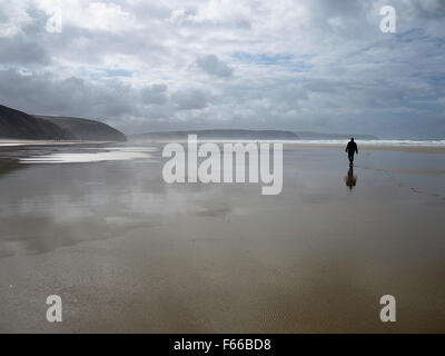 Einsame Gestalt zu Fuß über Sand - Strand / Seelandschaft mit Cloud gefüllt Himmel Stockfoto