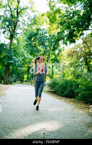 Junge blonde Frau im Park Joggen Stockfoto