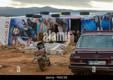 Libanon Beqaa Tal, Deir el Ahmad, Lager für syrische Flüchtlinge, Familie im Zelt von alten Kino Plakat gemacht, vor alten deutschen Mercedes Benz 230 E Gebrauchtwagen/LIBANON Bekaa-ebene Tal, Deir el Ahmad, Lager fuer Fluechtlinge syrische am Dorfrand, Familie im Zelt aus alten Kinoplakaten Stockfoto