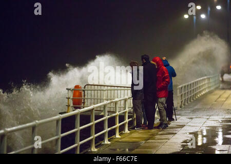 Aberystwyth, Wales, UK. 12. November 2015. Als Sturm Abigail verbinden Hits Aberystwyth in die dunklen Stong Winde und eine Flut um riesige Wellen zu erzeugen. Eine Gruppe von Menschen die Wellen zu beobachten. Bildnachweis: Alan Hale/Alamy Live-Nachrichten Stockfoto