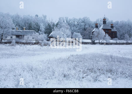 eine alte Kirche aus Holz unter den Bäumen im Schnee Stockfoto