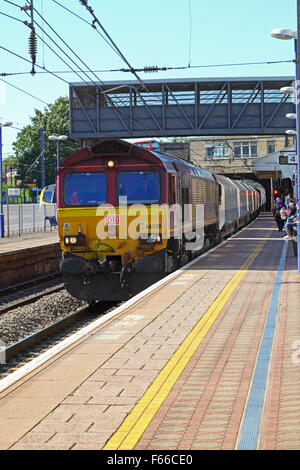 Ein Klasse 66 Lokomotive und nachfolgende Ballast Trichter Werbebande entlang der Plattform bei Hayes und Harlington in Richtung Signal SN284 oben Stockfoto