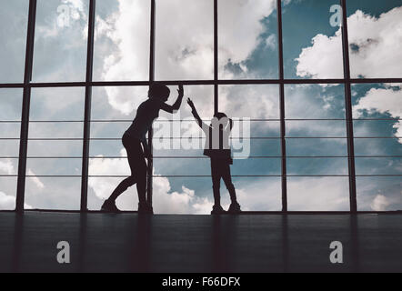 Silhouette von Mutter und Tochter in der Turnhalle Stockfoto