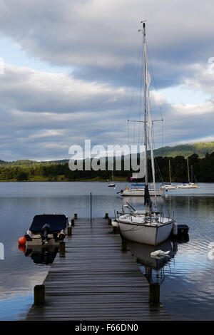 Kleine Yacht und Boote vertäut am Steg am Lake Windermere. Stockfoto