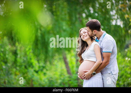 Glückliches junges Paar erwartet Baby im Sommerpark Stockfoto