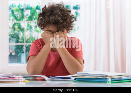 Junge verärgert mit seinen Hausaufgaben Stockfoto