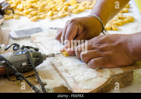 Jose Moquinche zeigt bohrende von Löchern in gefärbten und geformten pflanzliche Elfenbein. Stockfoto