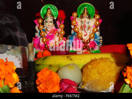 Devotional Göttin Maa Lakshmi und Lord Ganesha Statue mit einigen Süßigkeiten und Obst Stockfoto