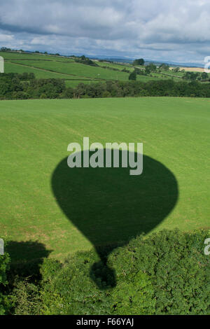 Schatten der Heißluftballon auf Landschaft, Cumbria, England. Stockfoto