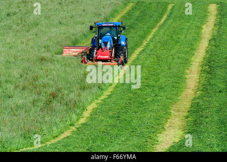 Mähen einer Wiese mit einem New Holland T7 Traktor mit Kvernland Front- und Seitenairbags Mähaufbereiter auf. Cumbria, UK. Stockfoto