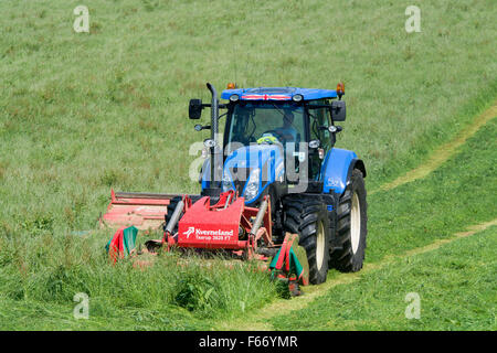 Mähen einer Wiese mit einem New Holland T7 Traktor mit Kvernland Front- und Seitenairbags Mähaufbereiter auf. Cumbria, UK. Stockfoto