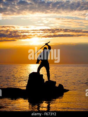 Mann mit Schwert auf dem sunset Stockfoto