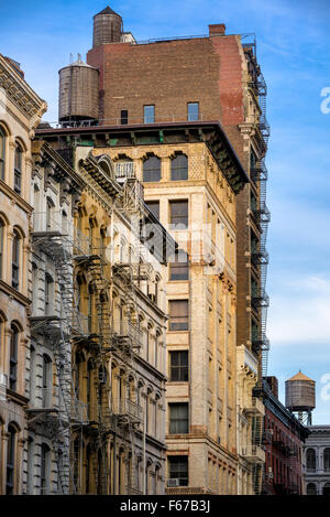 Soho Loft-Gebäude mit Feuerleiter und Wassertürme in Broome Street, Manhattan, New York City. Stockfoto