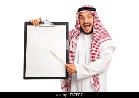 Junge aufgeregt arabischen hält ein Klemmbrett mit ein leeres Blatt Papier und deutete darauf mit einem Holzstab isoliert auf weißem Hintergrund Stockfoto
