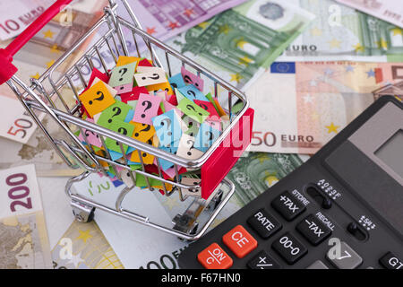 Euro-Banknoten, Warenkorb mit Fragezeichen und Taschenrechner. Hautnah. Stockfoto