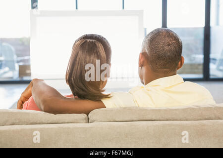 Schulter-Blick über lässige paar vor dem Fernseher Stockfoto