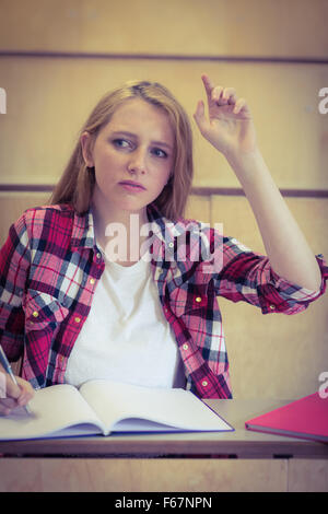 Unsicher, Student, heben der Hand während des Unterrichts Stockfoto