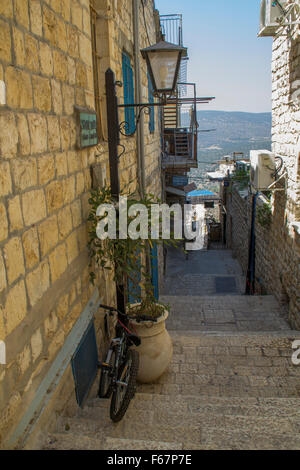 Safed, Israel - typische Straße Gasse in der Altstadt von Safed mit Steinmauern und blauen farbigen Türen. Blick auf die Berge umgeben Stockfoto