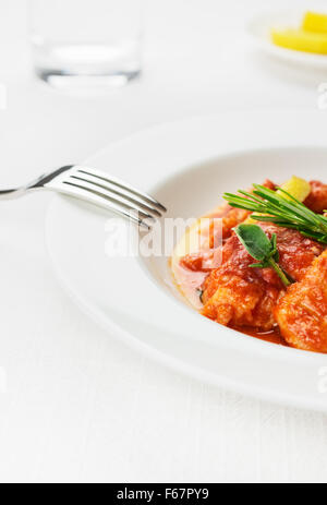 Kabeljau auf weiße Schale und Tischdecke. Frische Meeresfrüchte Rezept bekannt als Bacalao Pil Pil, Bacalao Vizcaina oder Baccalà Vicentina Witz Stockfoto