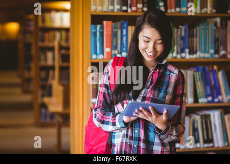 Lächelnd Schüler in der Bibliothek mit tablet Stockfoto