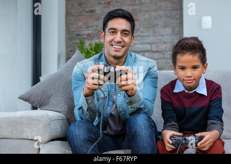 Glücklicher Vater spielen von Videospielen mit seinem Sohn Stockfoto