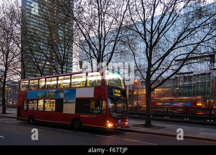 Doppelte Decker Busse vor modernen Glasgebäuden in London, Großbritannien Stockfoto