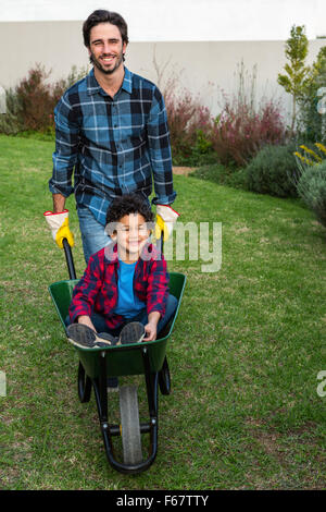 Vater mit Kind in der Barrow lächelnd Stockfoto